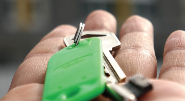 A hand with keys to a house